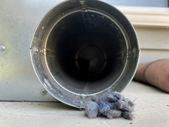 Holbrook Dryer Vent Cleaning technician using specialized equipment to clear severe dryer vent blockage in Holbrook